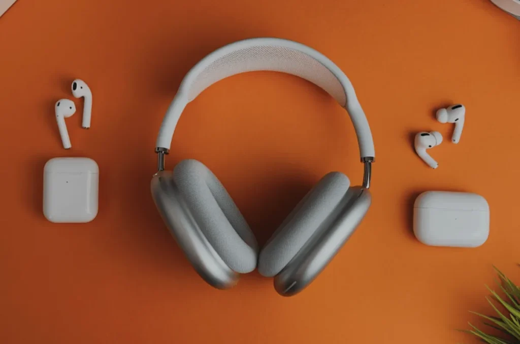 headphones and earbuds on orange background