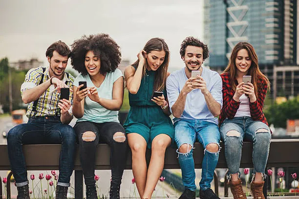 People on their phones on a bench happy