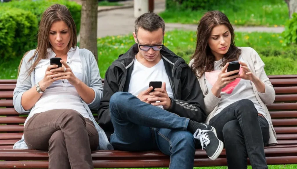 Social Media Changed Communication People on a bench on their phones