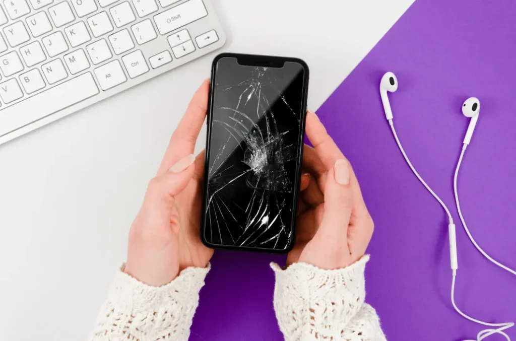 Woman's Hands Holding iPhone With Broken Screen