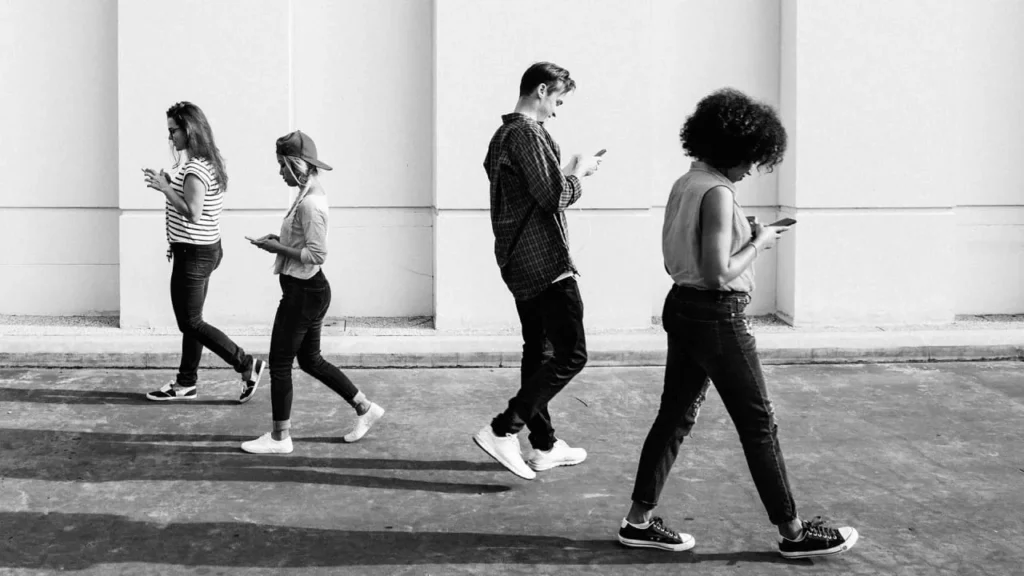 people-walking-looking-at-their-phones-black-and-white-photo